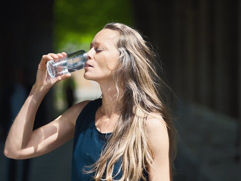 Frau trinkt Heilwasser aus dem bayerischen Staatsbad Bad Kissingen