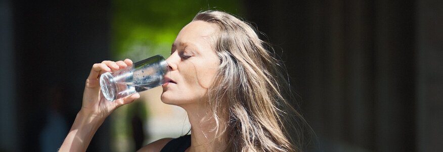 Frau trinkt Heilwasser aus dem bayerischen Staatsbad Bad Kissingen