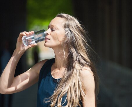 Frau trinkt Heilwasser aus dem bayerischen Staatsbad Bad Kissingen
