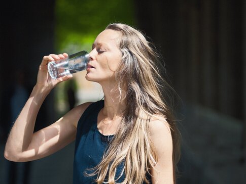 Frau trinkt Heilwasser aus dem bayerischen Staatsbad Bad Kissingen