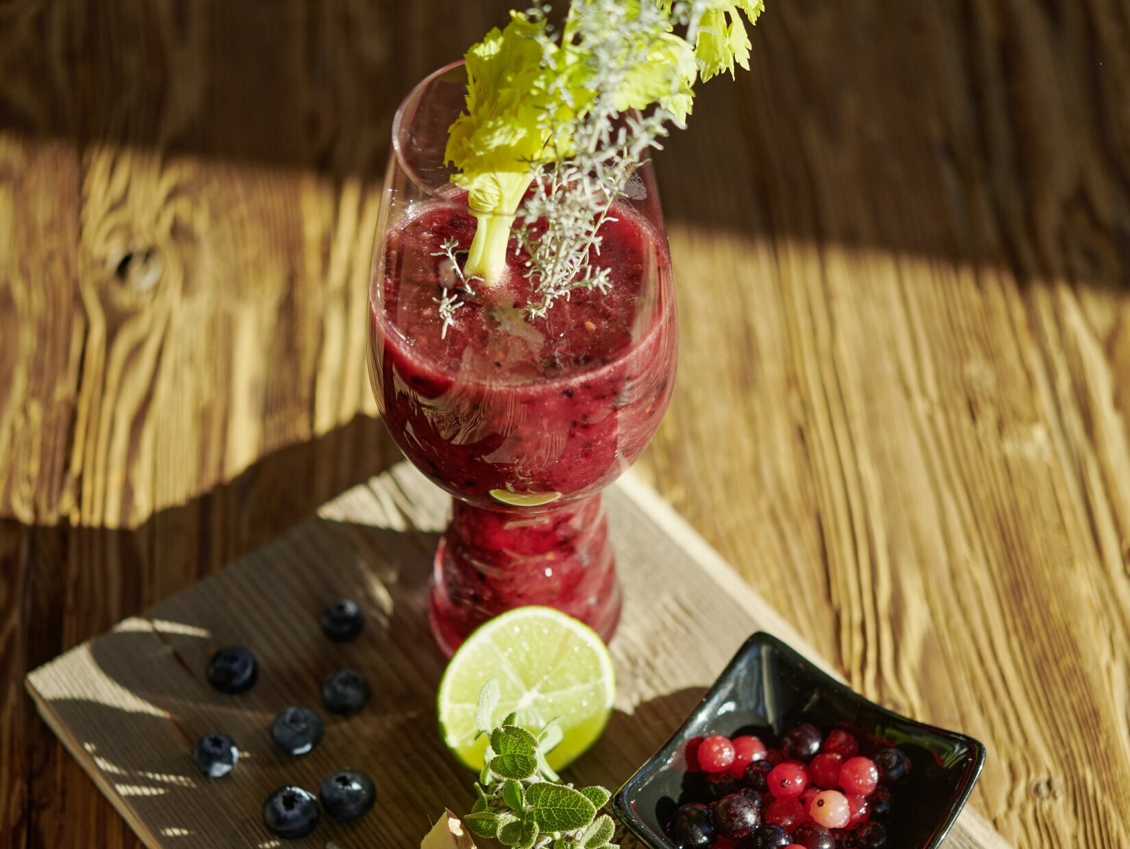 Hier sehen Sie ein frisch zubereitetes Gericht. Aus der Hand des Kochs fallen gerade noch die letzten Kräuter auf den Teller.