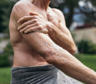 Mann reibt seine Arme mit dem Heilmittel Salz bei der Solekur ein