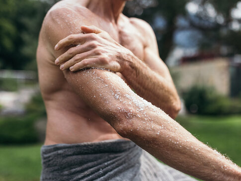 Mann reibt seine Arme mit dem Heilmittel Salz bei der Solekur ein