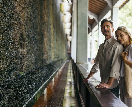 Ein Paar steht vor einer Mooswand und genießt die Sole Luft