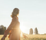 Frau geht im Sonnenlicht