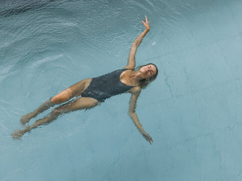 Frau entspannt und schwimmt im Heilwasser